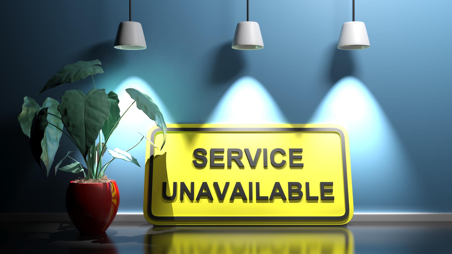 A sign saying Service Unavailable sits on a table with a leafy plant