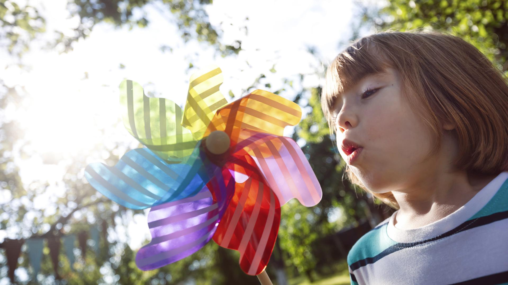 Photo of a child blowing on a pinwheel toy