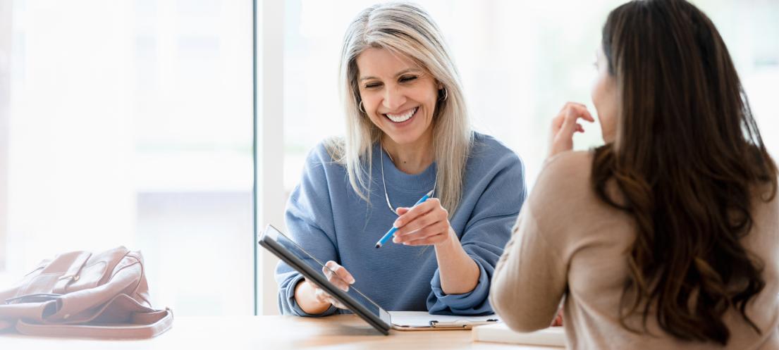 two women working together on a tablet