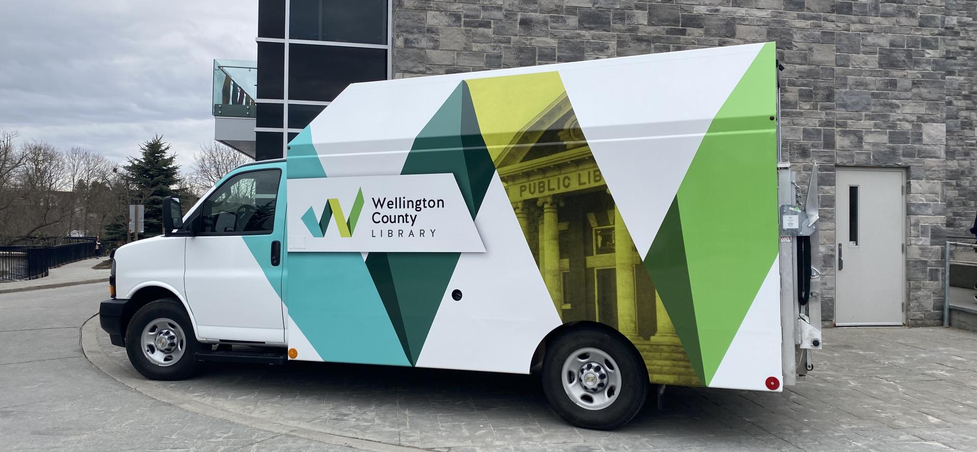 Courier van with a large letter W in teal, dark green, yellow, and light green on the side